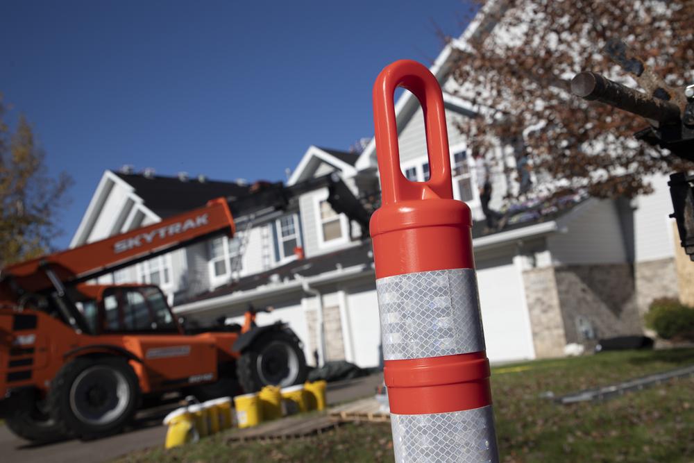 Jobsite safety cone with the crew and telehandler at a townhome re-roof